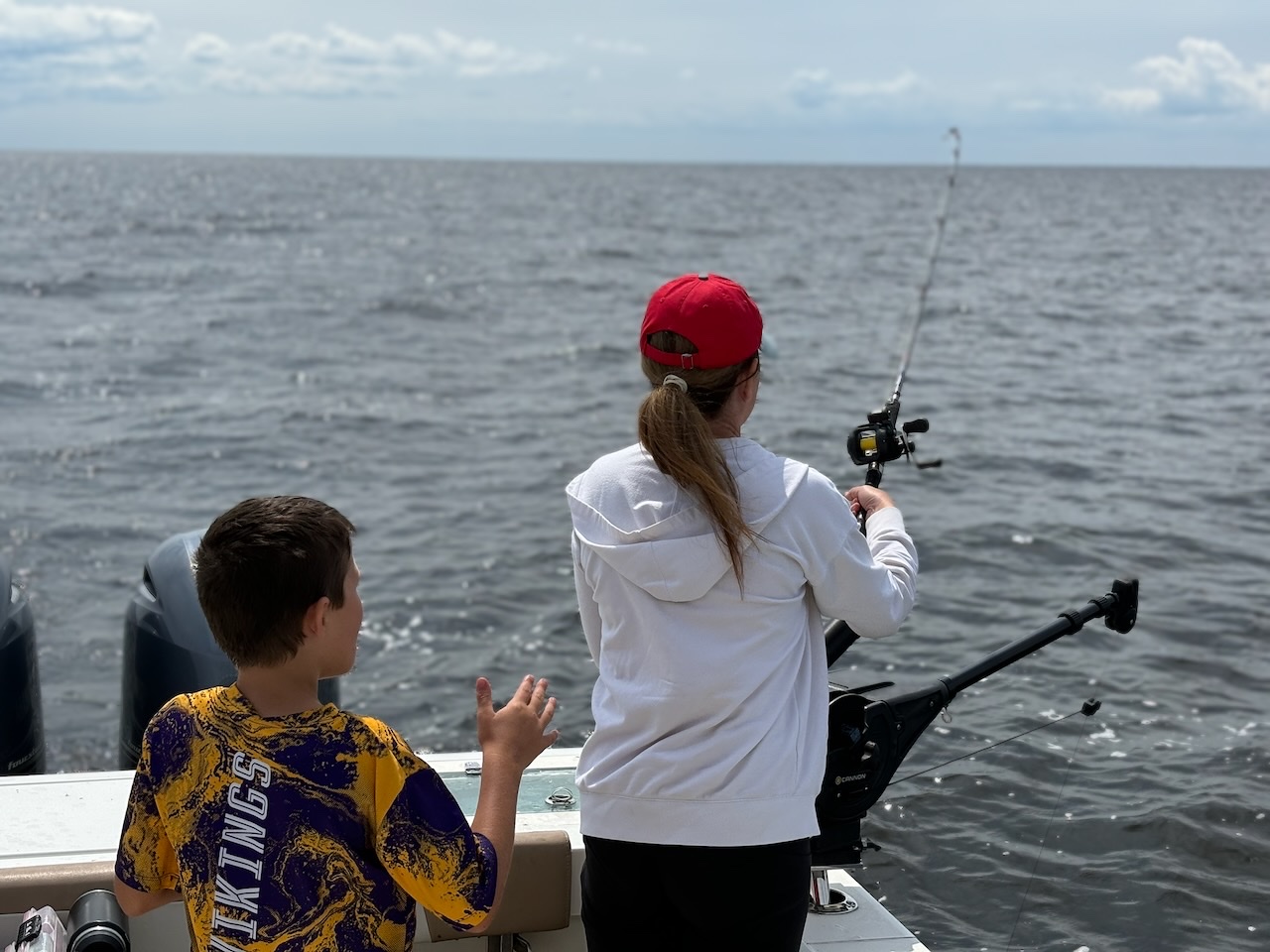 Two family members fishing together from a boat